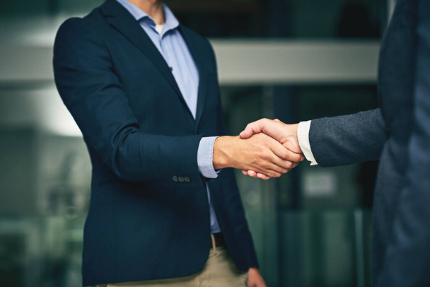 Closeup of businesswomen shaking hands during a meeting in an office. Colleagues finalizing a successful promotion, deal and merger. Coworkers greet, collaborate and negotiate during job interview. - Photo, image
