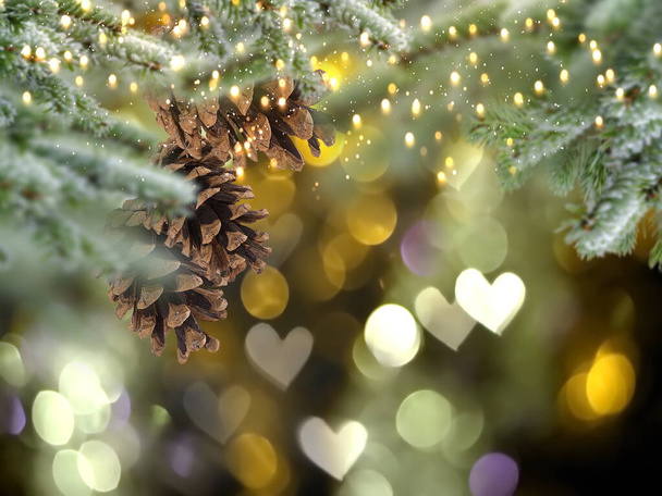 Christmas tree branch with cone and bokeh light heart sumbol gold bakcground template copy space - Foto, immagini