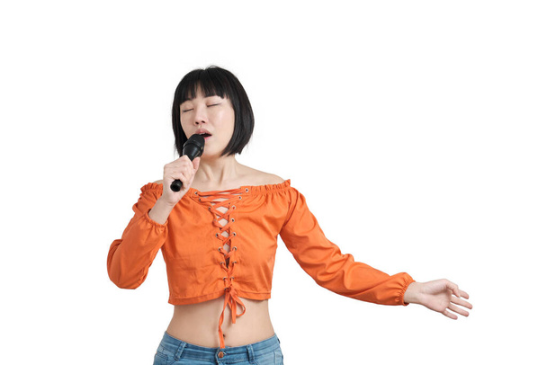 若いアジアの女性はマイクで歌います,白い背景に隔離された. - 写真・画像