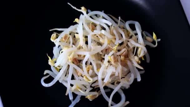 Mung bean sprouts on black background, flat view from above. Circular motion - Metraje, vídeo