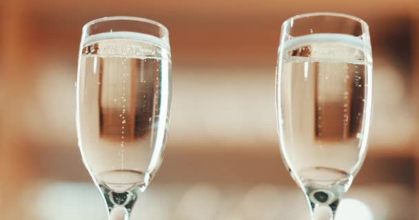 Champagne glasses, romance and celebration with alcohol in a restaurant for a birthday, anniversary or special occasion. Closeup of sparkling alcohol in glassware for a date from below with copyspace. - Filmagem, Vídeo