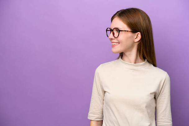 Young English woman isolated on purple background looking side - Fotoğraf, Görsel