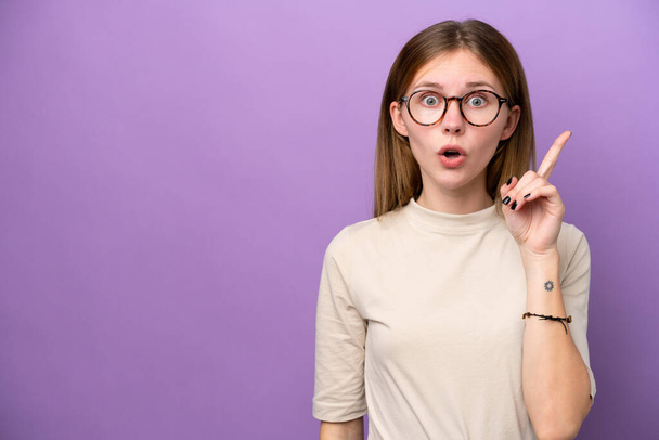 Young English woman isolated on purple background intending to realizes the solution while lifting a finger up - Photo, Image