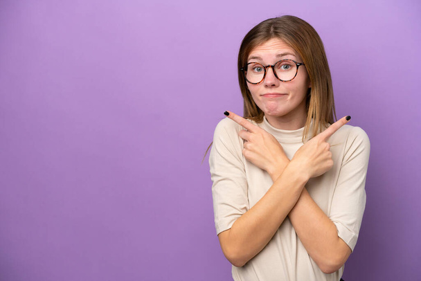 Young English woman isolated on purple background pointing to the laterals having doubts - Foto, Bild