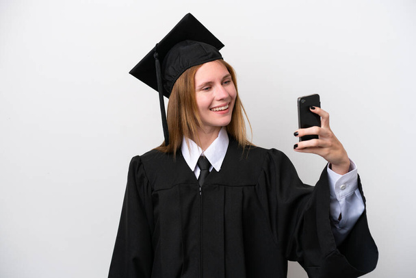 Young university graduate English woman isolated on white background making a selfie - Foto, Imagem