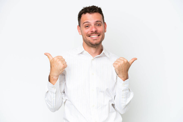 Молодий кавказький красивий чоловік ізольований на білому тлі з великими пальцями вгору жестом і посмішкою
 - Фото, зображення