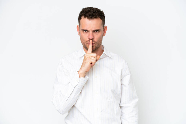 Mladý kavkazský pohledný muž izolovaný na bílém pozadí ukazující znamení mlčení gesto strkání prst do úst - Fotografie, Obrázek