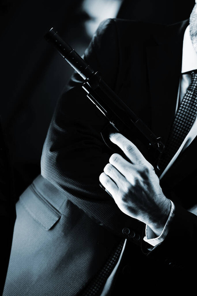 Добре одягнений чоловічий секретний агент детектив шпигун в костюмі і краватка тримає автоматичний пістолет
. - Фото, зображення