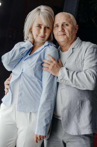 Ένας άντρας και μια γυναίκα αγκαλιάζονται σε μαύρο φόντο. - Φωτογραφία, εικόνα