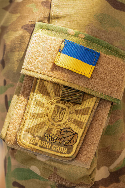 12 августа 2022 года Украина Оратов: "Шеврон Вооруженных Сил Украины" в камуфляжной форме. Крупный план, избирательный фокус. - Фото, изображение