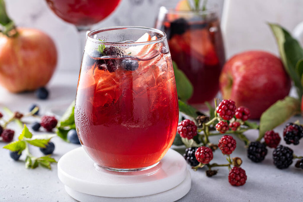 Fall berry and apple sangria in a glass with ice, refreshing fall cocktail or mocktail idea - Foto, Imagem
