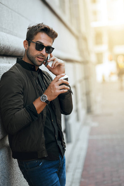 Would you like to meet up. a handsome young man making a phonecall while traveling through the city - 写真・画像