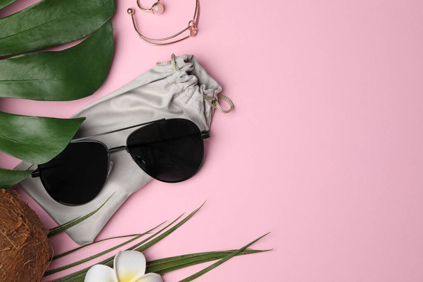 Stylish sunglasses with bag on pink background, flat lay. Space for text - Фото, зображення