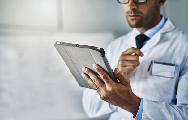 Every expert carries modern tools around. Closeup shot of an unrecognizable doctor working on a digital tablet - Foto, imagen