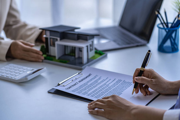 Home agents talk to new home buyers and offer good interest rates and calculate clients on mortgage financing to help make real estate concept decisions. - Fotoğraf, Görsel
