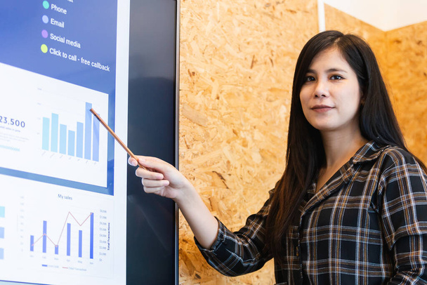 Asian young businesswoman presentation pointing digital board and looking at camera in meeting boardroom. brainstorming executive training business cocept. - Fotoğraf, Görsel