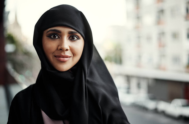 Мбаппе в деле успеха. Обрезанный портрет привлекательной молодой предпринимательницы, одетой в исламскую традиционную одежду, стоящей на балконе своего офиса - Фото, изображение