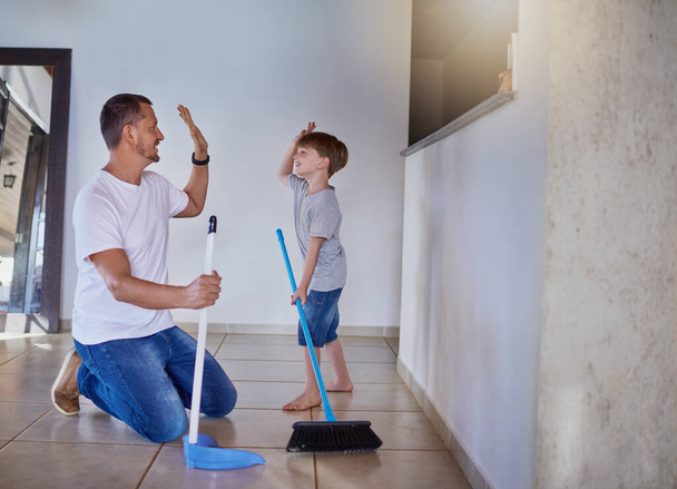 Good job buddy. a father and his little son high fiving each other while sweeping the floor at home - Φωτογραφία, εικόνα