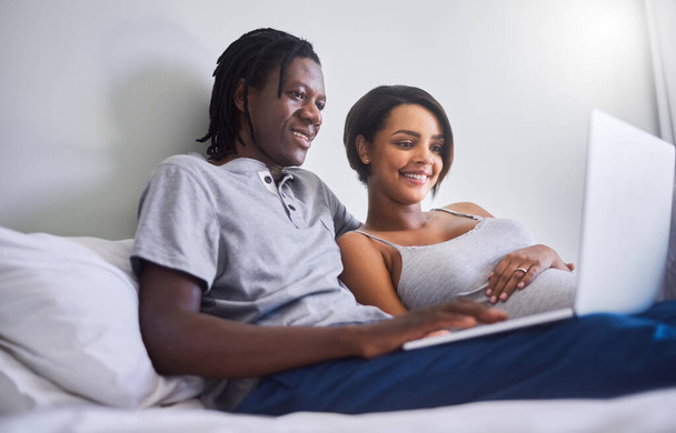 Lets check what this week of pregnancy holds. an expecting couple browsing the internet at home - Foto, afbeelding