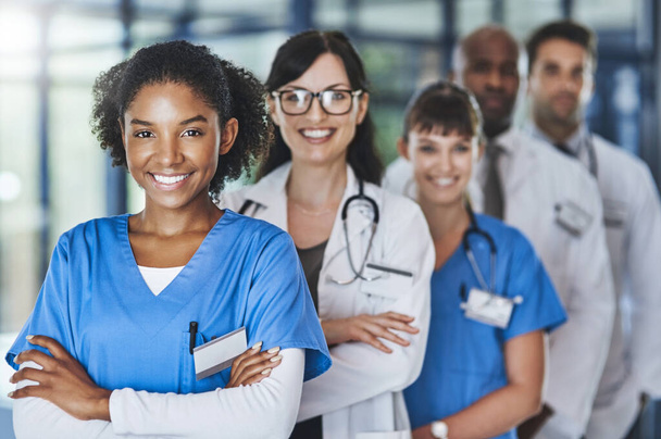 Ваше здоровье в наших интересах. Портрет разноплановой команды врачей, стоящих вместе в больнице - Фото, изображение