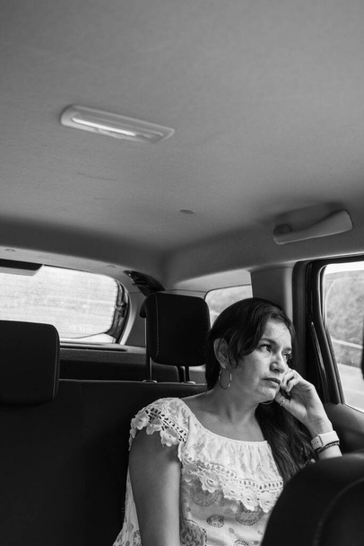 Beautiful business lady traveling in a car cloudy day in summertime - Photo, Image