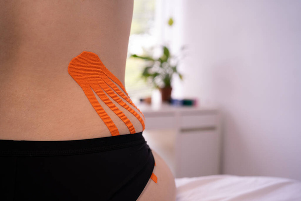 Weight loss concept. Kinesio taping of the female abdomen for weight loss. Anti-cellulite procedure with kinesiology tapes. Health and alternative medicine. - Photo, Image