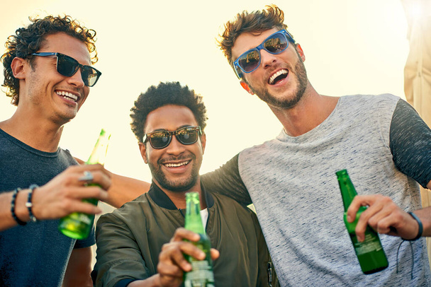 Первое правило выходных Отпразднуй это. группа молодых друзей, тусующихся и выпивающих вместе на улице - Фото, изображение
