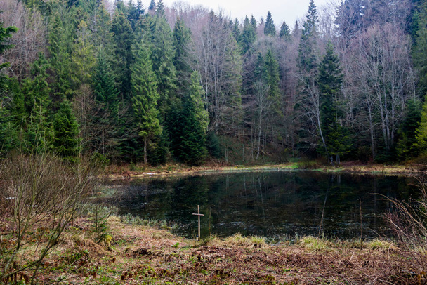 Polianytske lake in the forest in carpathian mountains and wooden cross, national park Skolivski beskidy, Lviv region of Western Ukraine - Foto, afbeelding