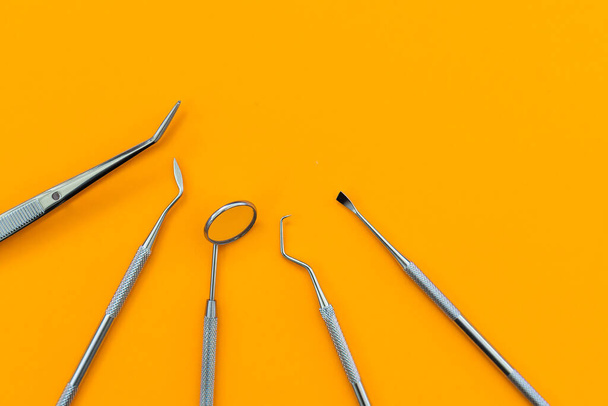 Professional Dentist tools in dental office: dentist mirror, forceps curved, explorer curved, dental explorer angular and explorer curved with chip, right. Dental Hygiene and Health. - Photo, image