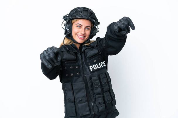 SWAT caucasian woman isolated on white background points finger at you while smiling - 写真・画像