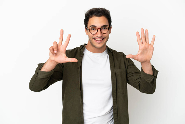 Caucasian handsome man over isolated white background counting eight with fingers - Fotó, kép