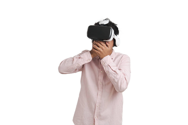 Молодий перуанський чоловік здивувався в гарнітурі віртуальної реальності. Ізольовані на білому тлі
. - Фото, зображення
