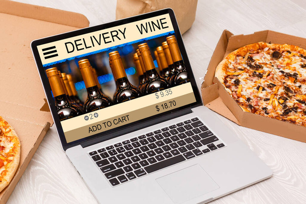 Buying wines online, home delivery concepts. screen laptop computer on table with wine bottle. - Foto, imagen
