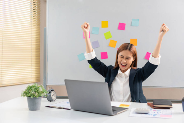 Concept of modern girl leadership, Businesswoman raises her arms in happiness after successful work. - Foto, afbeelding