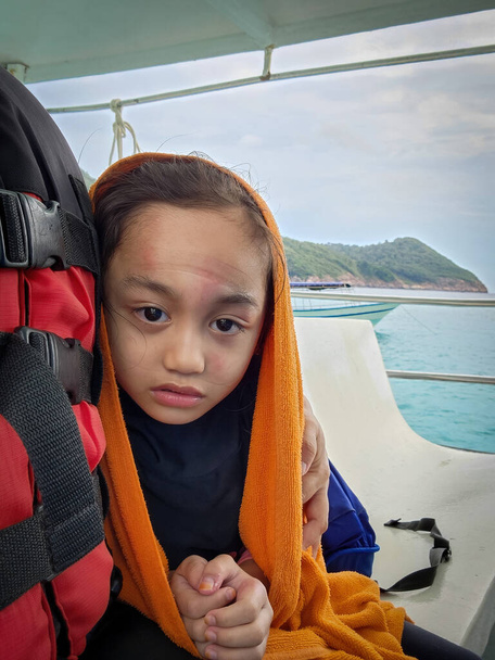 LIttle girl is shivering from cold being on the boat at the sea. - Photo, Image