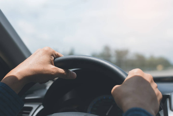 Man holding streering wheel, driving a car in sunny day, close up - Valokuva, kuva
