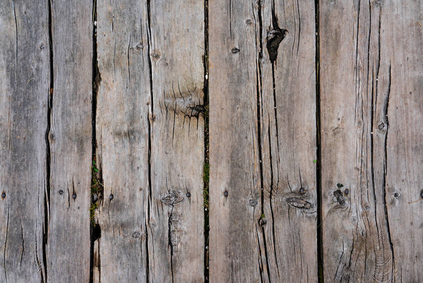 Texture of ground wooden planks. Old wood damaged by time and cracks along the boards. - Foto, imagen