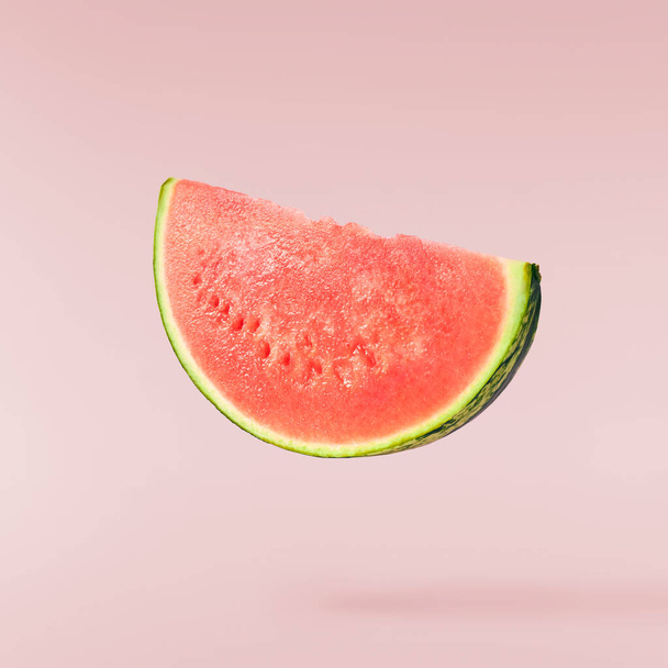 Fresh raw watermelon falling in the air isolated on pink background. Food levitation or zero gravity conception. High resolution image. - 写真・画像