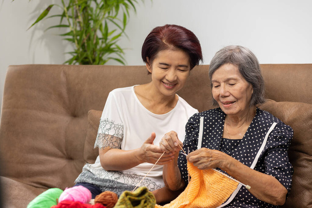 Ηλικιωμένη γυναίκα και κόρη πλέξιμο μαζί για την προστασία της άνοιας και απώλεια μνήμης. - Φωτογραφία, εικόνα