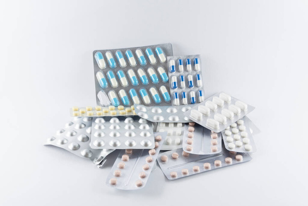 Carton of different pills, medicines, pills stacked on white background. Medical supplies. - Fotó, kép
