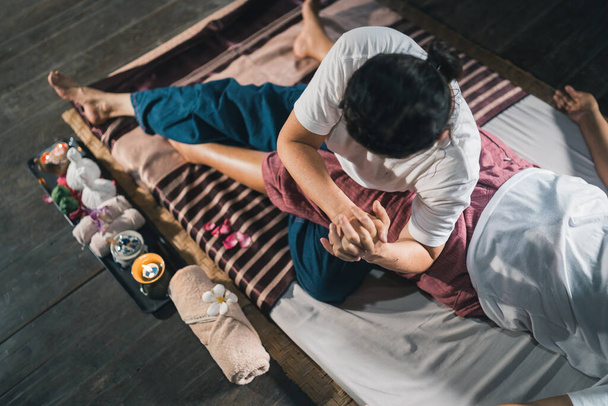 Масаж і спа розслаблююче лікування офісного синдрому традиційний тайський масажний стиль. Асаїн старша жінка-масажистка робить масаж рукою, болем в спині, болем в руці, ногами і стресом для старої втомленої жінки
. - Фото, зображення