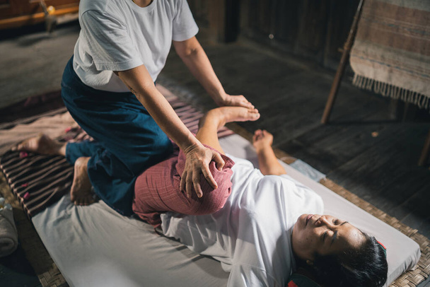 Massage and spa relaxing treatment of office syndrome traditional thai massage style. Asain senior female masseuse doing massage treat hand, back pain, arm pain, foot and stress for old woman tired. - Foto, immagini