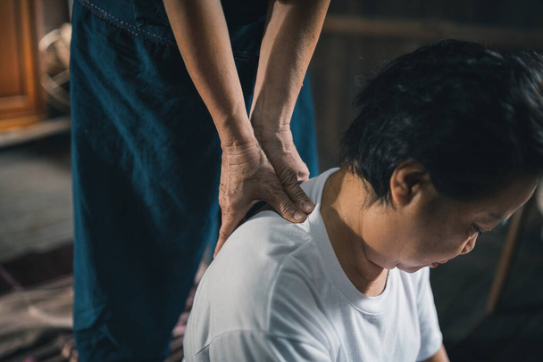 Μασάζ και spa χαλαρωτική θεραπεία του συνδρόμου γραφείου παραδοσιακό ταϊλανδέζικο στυλ μασάζ. Asain ανώτερος γυναικεία μασέρ κάνει μασάζ θεραπεία χέρι, πόνο στην πλάτη, πόνος στο χέρι, το πόδι και το άγχος για ηλικιωμένη γυναίκα κουρασμένος. - Φωτογραφία, εικόνα