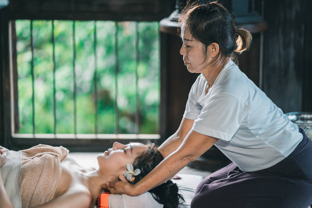 Massagem e spa tratamento relaxante da síndrome de escritório tradicional tailandês estilo de massagem. Asain massagista feminina fazendo massagem tratar dor nas costas, dor no braço e estresse para a mulher de escritório cansado do trabalho. - Foto, Imagem