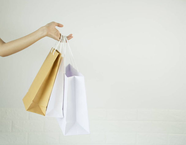 Paper shopping bags, on white background, female hands, holding shopping bags, concept, shopping mall shopping frenzy. - Photo, image