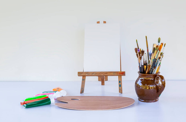 Artist's workplace. Canvas, paints, brushes and palette. - 写真・画像