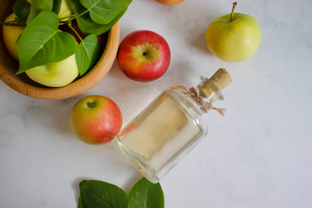Яблочный уксус в бутылке, свежие яблоки - Фото, изображение