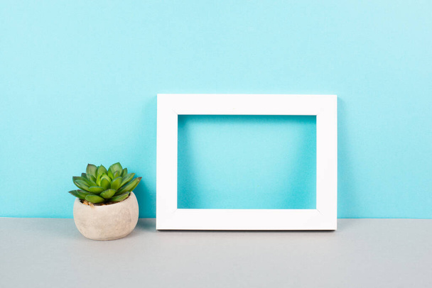 Home interior poster mock up with wooden frame, cactus in a pot, blue wall background, copy space for text and pictures - Foto, Imagen