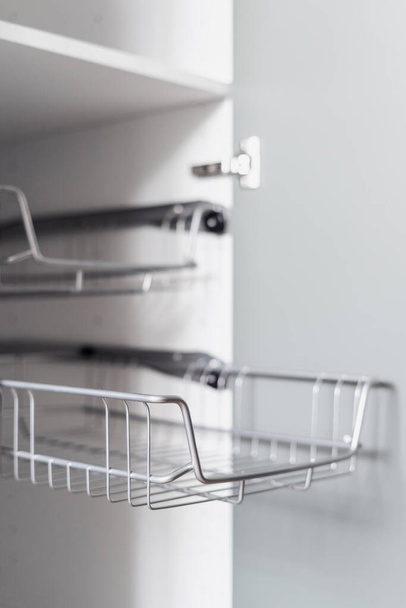 empty metal shelf for clothes in wooden closet or storage organization concept in dressing room, closeup - Foto, immagini