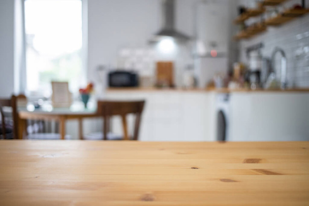 empty wooden tabletop and blurred kitchen mock up for product display - Foto, Imagem